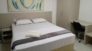 Ein Hotelzimmer mit Bett, Schreibtisch und Stuhl.
