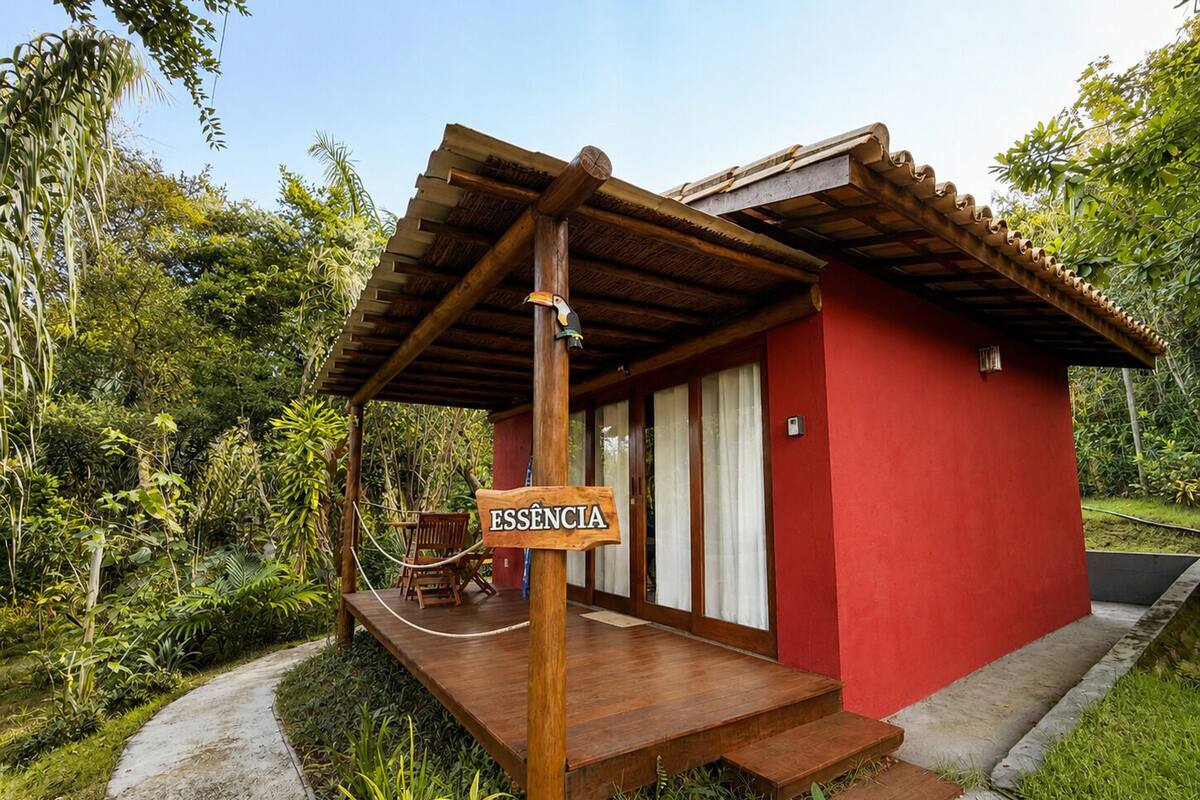 A red building with a wooden porch, a sign reading 'ESSENCIA,' and a hammock.