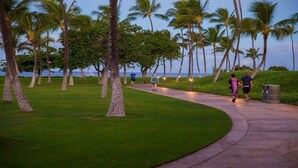 A paved walkway lined with palm trees and a view of the ocean. - Your Resort Home! Walk to Disney & Beach! (Kapolei)