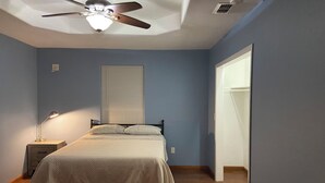 A bedroom with a bed, a ceiling fan, a bedside lamp, and a window with blinds. - Beautiful 3-bedroom townhome with AC in charming Brownsville (Brownsville)