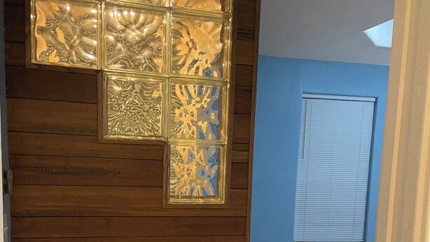 A room with wooden paneling, a blue wall, and a window with a decorative glass panel. - Beautiful 3-bedroom townhome with AC in charming Brownsville (Brownsville)