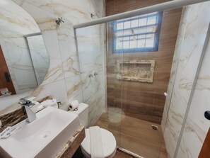 Villa | Badkamer | Een haardroger, handdoeken, toiletpapier