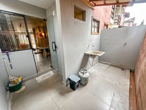 Une salle de bain avec une douche, un lavabo et un sol carrelé.