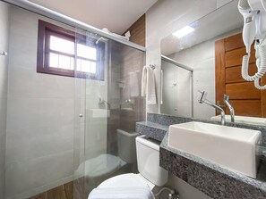 Villa | Badkamer | Een haardroger, handdoeken, toiletpapier
