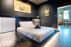 Ein modernes Schlafzimmer mit einem großen Bett, einer Kopfstütze mit vertikalen Lamellen und Kunstwerken an den Wänden.