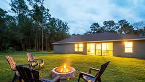 A house with a fire pit in the backyard, surrounded by chairs. - Springs Basecamp - 4BR Near Rainbow and Manatees (Dunnellon)