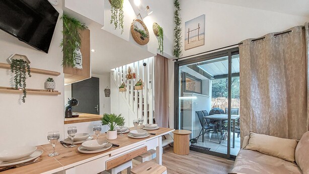 A modern dining area with a wooden table set for two, a sofa, and a view of the outdoors. - Awesome home in Meschers-sur-Gironde with WiFi (Meschers-sur-Gironde)