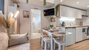 A modern kitchen with white cabinets, a wooden dining table, and bar stools. - Awesome home in Meschers-sur-Gironde with WiFi (Meschers-sur-Gironde)