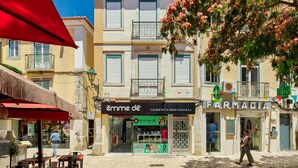 Une vue d’une rue avec une pharmacie et une boutique de produits de beauté appelée « Emma de ».
