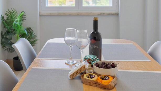 A dining table with two wine glasses, a bottle of wine, a bowl of cherries, and a box of cheese. - Lisboa no Sado - By Y Concept (Setúbal)