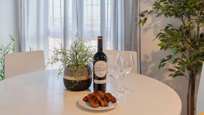 Ett matbord med en flaska Vinho de Ganso, en tallrik mat och ett vinglas.