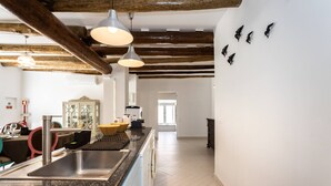 Eine moderne Küche mit Granit Arbeitsplatten, Edelstahlgeräten und freiliegenden Holzbalken.