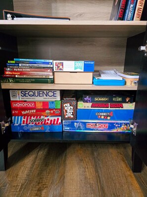 Une bibliothèque contenant divers jeux de société et livres.