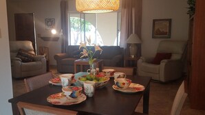 A dining area with a table set for four, surrounded by two sofas and a chair. - Beautiful 2-bedroom Golf house in Green Valley perfect for relaxing getaway (Green Valley)