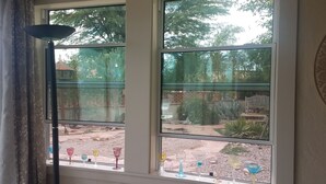 A room with two windows, each with a view of a garden and a patio area. - Beautiful 2-bedroom Golf house in Green Valley perfect for relaxing getaway (Green Valley)