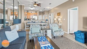 A living room with a sofa, armchairs, a coffee table, and a dining area with a table and chairs.