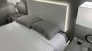 Ein modernes Hotelzimmer mit einem großen Bett, einer Nachttischlampe und einem Nachttisch.