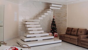 Een modern interieur met een wenteltrap, een kerstboom en een bruine bank.