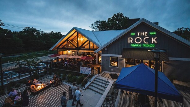 Ein Restaurant namens "The Rock" mit Außenbestuhlung und einer Feuerstelle.