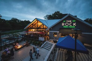 A restaurant named "The Rock" with outdoor seating and a fire pit area.