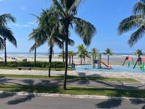 Ein Park direkt am Strand mit Palmen, einem Spielplatz und Blick auf den Ozean.