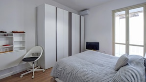 A bedroom with a bed, a chair, a TV, a wardrobe, and a window. - 2 bedroom cozy apartment in Staletti (Staletti)
