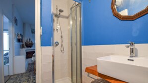 A bathroom with a glass-enclosed shower, a white sink, and a mirror on the wall. - 2 bedroom cozy apartment in Staletti (Staletti)