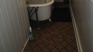 Un baño pequeño con una bañera blanca, inodoro y cortina de ducha.