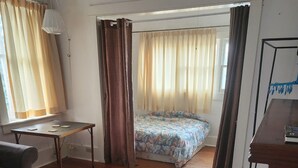 Una habitación con cama, mesa y sofá.