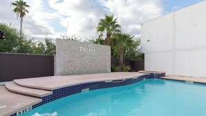 Piscina com muro de pedra com a inscrição 