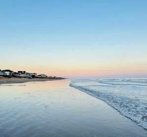 Een strand met een rij huizen langs de kust.