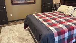 Ein Schlafzimmer mit einem großen Bett, einem Bild an der Wand und einer Tür zu einem anderen Raum.