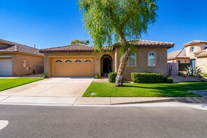A residential house with a garage, a well-maintained lawn, and a tree in the front yard. - Indio 4BR Golf Course Oasis. Private Saltwater Pool, Spa & Casita (Indio)
