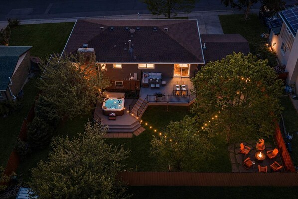 A residential property with a hot tub, outdoor seating, and a deck.