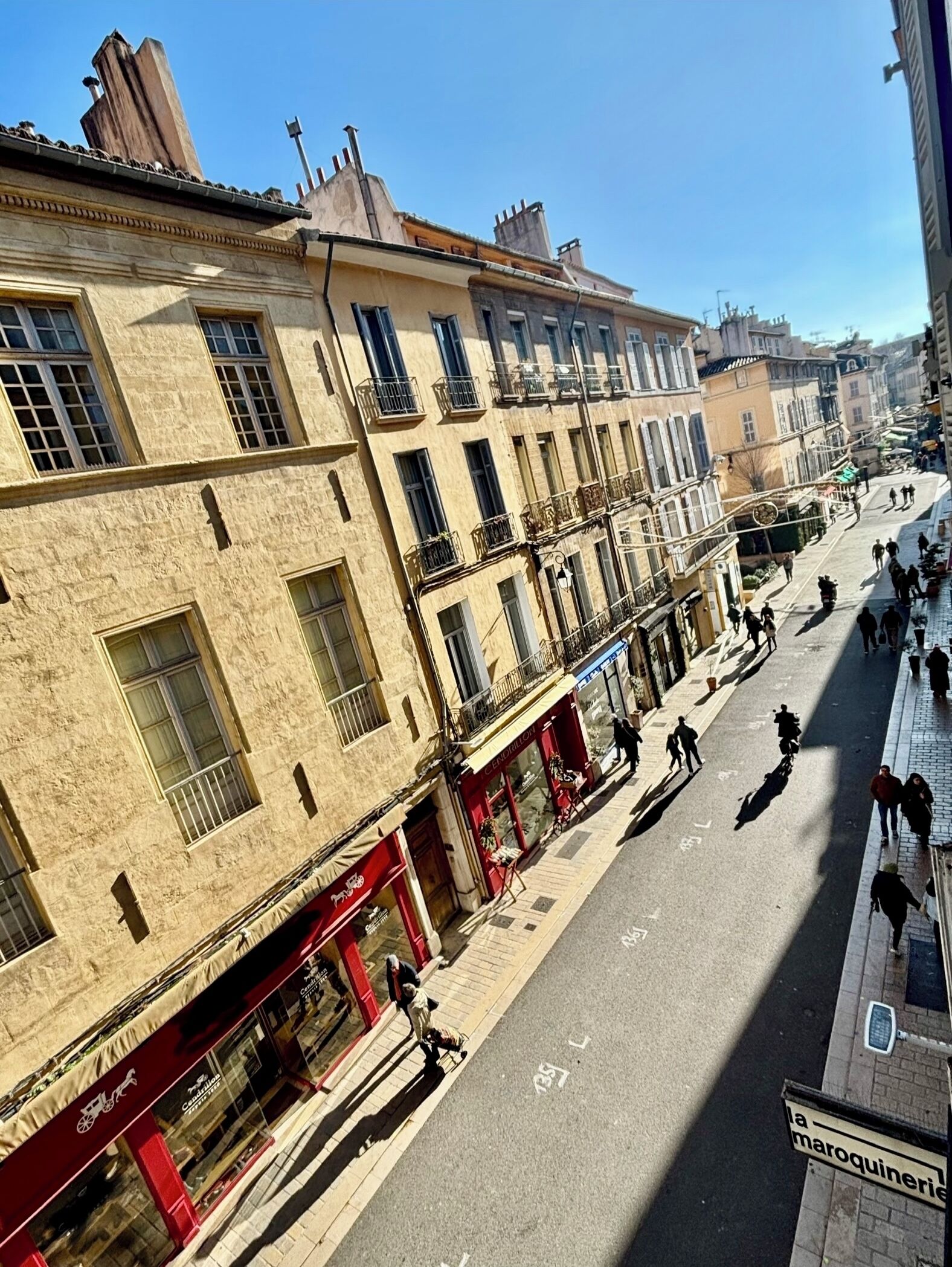 A street view with buildings, shops, and pedestrians.