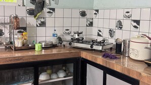 Een keuken met een houten aanrecht, een gasfornuis en een spoelbak. Er is een raam met uitzicht op groen.