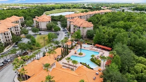 Ein Resort mit mehreren Gebäuden, einem Schwimmbad und üppiger Bepflanzung.