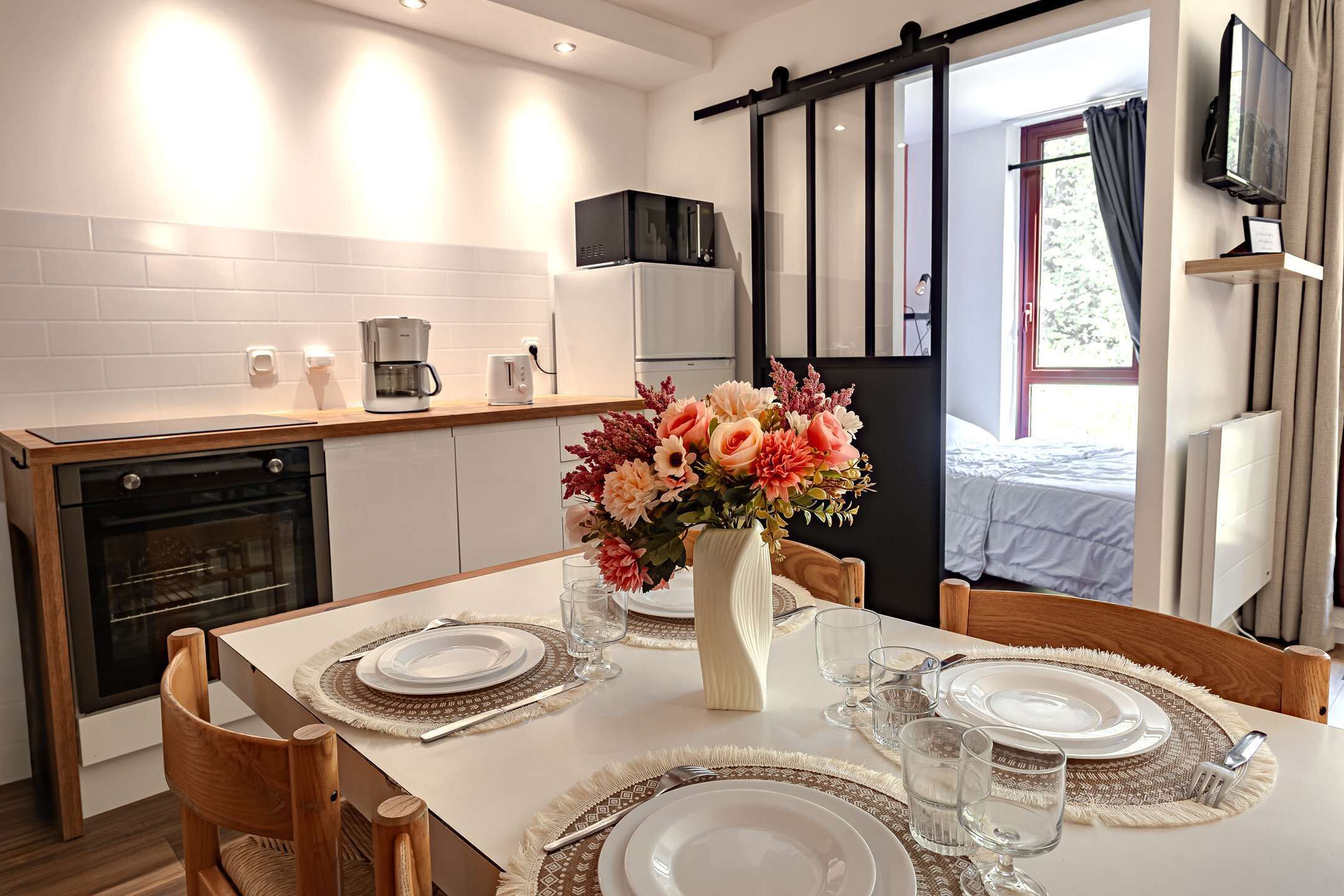 Een koelkast, een oven, een vaatwasser, kookgerei, borden en bestek