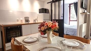 Een koelkast, een oven, een vaatwasser, kookgerei, borden en bestek