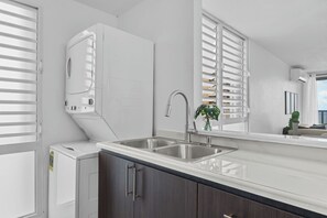 A modern kitchen with a double sink, a built-in washer and dryer, and a large window with blinds. - Designer remodeleded apt.View, Parking, location,NEW listing! (Luquillo)