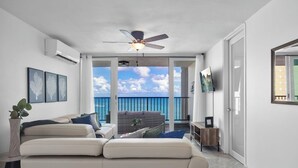 A modern living room with a balcony, white walls, and a ceiling fan. - Designer remodeleded apt.View, Parking, location,NEW listing! (Luquillo)