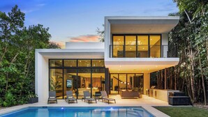 A modern two-story house with a swimming pool, large windows, and a well-maintained garden. - Villa Strata: Modern 5 BED +POOL, minutes from The Grove, Brickell & Downtown (Miami)