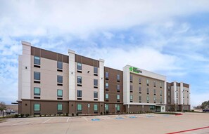 Un hôtel à plusieurs étages au design moderne, dont la façade est ornée d’un logo vert bien visible.