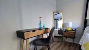 A bedroom with a wooden desk, a chair, a bedside table with a lamp, and a bed with a yellow blanket. - Romantic Boutique Getaway with Modern Remodel (Chelan)