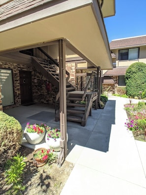 A residential building with a covered outdoor area, a staircase, and potted plants. - Romantic Boutique Getaway with Modern Remodel (Chelan)