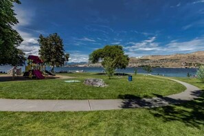 A park with a playground, a walking path, and a lake view. - Spacious Family Friendly Townhome at Lakeside Park (Chelan)
