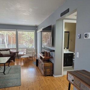 A living room with a sofa, chairs, a coffee table, a TV, and a wooden cabinet. - Spacious Family Friendly Townhome at Lakeside Park (Chelan)