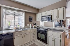 A kitchen with a dishwasher, stove, microwave, and cabinets. - Spacious Family Friendly Townhome at Lakeside Park (Chelan)
