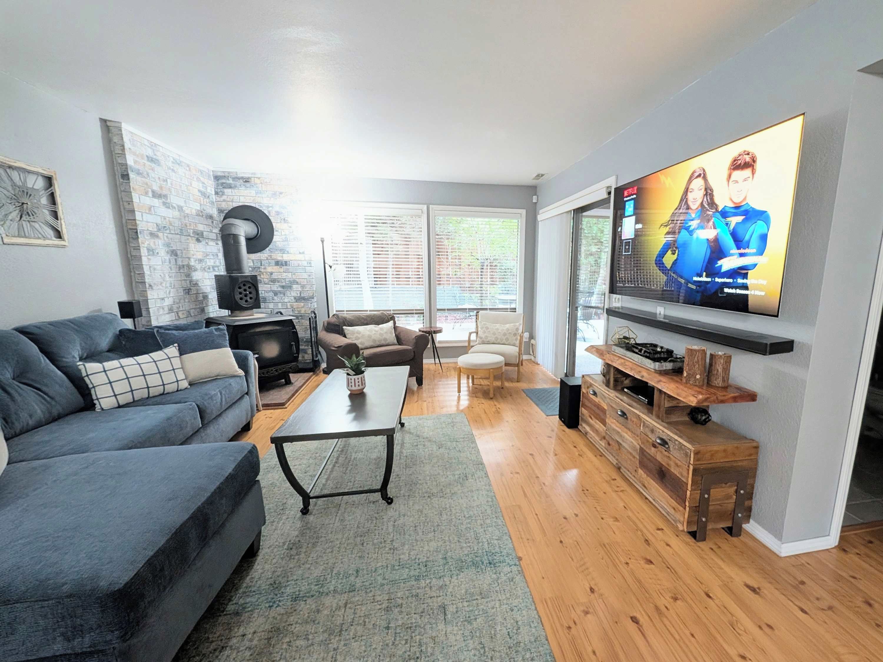 A living room with a fireplace, a sofa, a coffee table, and a TV mounted on the wall.