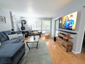 A living room with a fireplace, a sofa, a coffee table, and a TV mounted on the wall. - Spacious Family Friendly Townhome at Lakeside Park (Chelan)